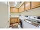 Well-equipped laundry room with a full-size washer and dryer, sink, and built-in cabinets at 138 Wentworth Dr, Henderson, NV 89074
