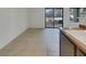 Bright living room with tile floors and sliding door access to the outdoor space, viewed from kitchen at 1575 W Warm Springs Rd # 1111, Henderson, NV 89014