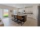 Open kitchen with white cabinets, granite countertops, a large island with bar stools, and a sliding glass door to the backyard at 1876 Jamie Brook Pl, North Las Vegas, NV 89084