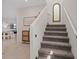 Carpeted staircase featuring a decorative mirror and accent piece, bathed in natural light at 1876 Jamie Brook Pl, North Las Vegas, NV 89084