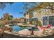 A backyard featuring a sparkling pool, spa, rock waterfall and a covered patio at 20 High Sierra Dr, Henderson, NV 89074