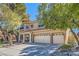 Charming two-story home with mature trees and a three-car garage on a sunny day at 20 High Sierra Dr, Henderson, NV 89074