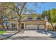 Charming two-story home with well-manicured landscaping, mature trees, and a three-car garage on a sunny day at 20 High Sierra Dr, Henderson, NV 89074