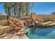 The beautiful pool features rock waterfalls, mature trees and a relaxing lounge area at 20 High Sierra Dr, Henderson, NV 89074