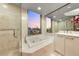This bathroom offers a glass-enclosed shower, soaking tub, and a stunning city view at 222 Karen Ave # 3908, Las Vegas, NV 89109
