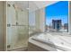 This bathroom offers a tub and shower, encased in glass, with amazing views from its oversized window at 222 Karen Ave # 3908, Las Vegas, NV 89109