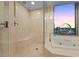 This bathroom has a bathtub, glass-enclosed shower with seating, and an outside view at 222 Karen Ave # 3908, Las Vegas, NV 89109