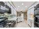 Open-concept kitchen showcasing stainless appliances, a breakfast bar, and wood-look tile flooring at 2836 Floral Peak Dr, Henderson, NV 89074