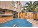 Private patio with custom bar, tv, wood fence, desert landscaping, and sliding door access at 2836 Floral Peak Dr, Henderson, NV 89074