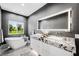 Bright bathroom features a soaking tub and granite countertop with dual sinks and an LED mirror at 2861 Queens Courtyard Dr, Las Vegas, NV 89109