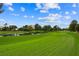 A view of the lush green golf course with a scenic pond and blue skies with clouds at 2861 Queens Courtyard Dr, Las Vegas, NV 89109