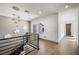 Hallway with modern chandelier, stylish railing and wood floors leads to other areas of the home at 2861 Queens Courtyard Dr, Las Vegas, NV 89109