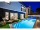 Backyard pool at twilight with modern design, lush landscaping, patio, and lounge chairs at 2861 Queens Courtyard Dr, Las Vegas, NV 89109