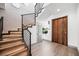 Modern staircase featuring wood steps, sleek metal railings, and ambient lighting for a stylish look at 2861 Queens Courtyard Dr, Las Vegas, NV 89109