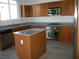 Bright kitchen with stainless steel appliances, a kitchen island, and wooden cabinets at 3104 Naggio Shores Ave, Las Vegas, NV 89141