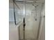 A close view of a glass shower door with a shower head and new features at 3104 Naggio Shores Ave, Las Vegas, NV 89141