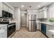 Functional kitchen with stainless steel appliances, light gray cabinets, tile flooring, and modern fixtures at 3151 Soaring Gulls Dr # 1049, Las Vegas, NV 89128