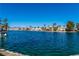 Beautiful lake view featuring waterfront homes with lush landscaping, and the clear blue water reflecting a cloudless sky at 3151 Soaring Gulls Dr # 1049, Las Vegas, NV 89128