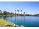 Picturesque lake view with lush landscaping, palm trees, and community amenities under a bright blue sky at 3151 Soaring Gulls Dr # 1049, Las Vegas, NV 89128