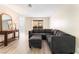 Bright living room featuring a comfortable gray sectional sofa, wood-look flooring, and access to a balcony at 3151 Soaring Gulls Dr # 1049, Las Vegas, NV 89128