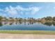 Scenic view of waterfront homes reflected in the tranquil lake, set against a backdrop of clear blue skies and scattered clouds at 3151 Soaring Gulls Dr # 1049, Las Vegas, NV 89128