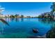 A serene waterfront view showcases calm waters with homes lining the shore, complemented by clear blue skies and palm trees at 3151 Soaring Gulls Dr # 1049, Las Vegas, NV 89128