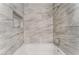 Bathroom tub featuring a tile surround, shower fixture, and shampoo niche at 3151 Soaring Gulls Dr # 2113, Las Vegas, NV 89128