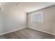 This bedroom features new gray hardwood floors and a large window, offering a simple, clean space at 3151 Soaring Gulls Dr # 2113, Las Vegas, NV 89128