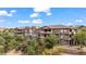 Beautiful exterior of a multi-story building featuring balconies with stone accents and mature trees at 405 Paradise Pkwy # 170, Mesquite, NV 89027