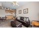 Cozy living room with kitchen, brown leather sofa, kitchenette, and overhead fan at 405 Paradise Pkwy # 170, Mesquite, NV 89027