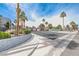 Community entrance with lush landscaping, mature trees, and a charming guardhouse, offering a welcoming and secure entry at 5199 Caliente St # 63, Las Vegas, NV 89119