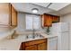 This kitchen features wood cabinets, stainless steel sink and a white refrigerator at 5199 Caliente St # 63, Las Vegas, NV 89119