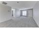Spacious living room with gray carpet, neutral walls, and a bright window creating a cozy atmosphere at 5199 Caliente St # 63, Las Vegas, NV 89119