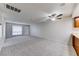 Bright living area seamlessly connects to kitchen, complete with plush carpet flooring, and a ceiling fan at 5199 Caliente St # 63, Las Vegas, NV 89119