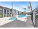 A community pool area with a spa, surrounded by palm trees and well-maintained buildings under a bright, sunny sky at 5199 Caliente St # 63, Las Vegas, NV 89119