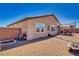 View of the home's backyard featuring desert landscaping, a fire pit, and covered patio at 5360 S Chippewa St, Pahrump, NV 89061