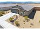 Exterior elevation featuring desert landscaping, gray two car garage, and tile roof at 5360 S Chippewa St, Pahrump, NV 89061