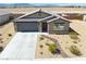 Exterior elevation featuring desert landscaping, gray two car garage, and tile roof at 5360 S Chippewa St, Pahrump, NV 89061