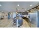 Spacious kitchen with stainless steel appliances, granite countertops, dark cabinetry, and an island with bar stool seating at 5360 S Chippewa St, Pahrump, NV 89061