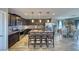 Modern kitchen with dark wood cabinetry, stainless steel appliances, granite countertops, and an island with seating at 5360 S Chippewa St, Pahrump, NV 89061