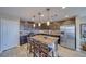 This is a modern kitchen with dark wood cabinetry, stainless steel appliances and a granite island with seating at 5360 S Chippewa St, Pahrump, NV 89061