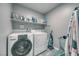 Functional laundry room with modern washer and dryer, storage shelves, and essential appliances at 5360 S Chippewa St, Pahrump, NV 89061
