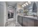 Well-lit bathroom with dual sinks, granite counters, a shower, and access to a well-organized walk-in closet at 5360 S Chippewa St, Pahrump, NV 89061