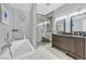 Sleek bathroom with soaking tub, glass-enclosed shower, and double vanity with stylish accents at 6116 Golden Saddle St, Las Vegas, NV 89130