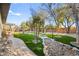 Beautiful backyard featuring artificial turf, trees and a stone pathway creating a tranquil outdoor space at 6907 May Basket Ave, Las Vegas, NV 89131