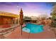 Backyard features a beautiful pool with a rock waterfall, hot tub, fountain, and covered patio at 6907 May Basket Ave, Las Vegas, NV 89131