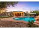 Inviting backyard oasis with an in-ground pool, spa, waterfall, and covered patio at 6907 May Basket Ave, Las Vegas, NV 89131