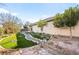 Manicured backyard showing green artificial turf and artistic rock and stone landscape design, along with a built-in pool feature at 6907 May Basket Ave, Las Vegas, NV 89131