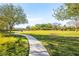 Picturesque community park showing lush green lawns, mature trees and a paved walking path beneath a beautiful sky at 6907 May Basket Ave, Las Vegas, NV 89131