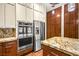 Updated kitchen with stainless steel appliances, modern cabinets, granite countertops, and wood laminate flooring at 6907 May Basket Ave, Las Vegas, NV 89131